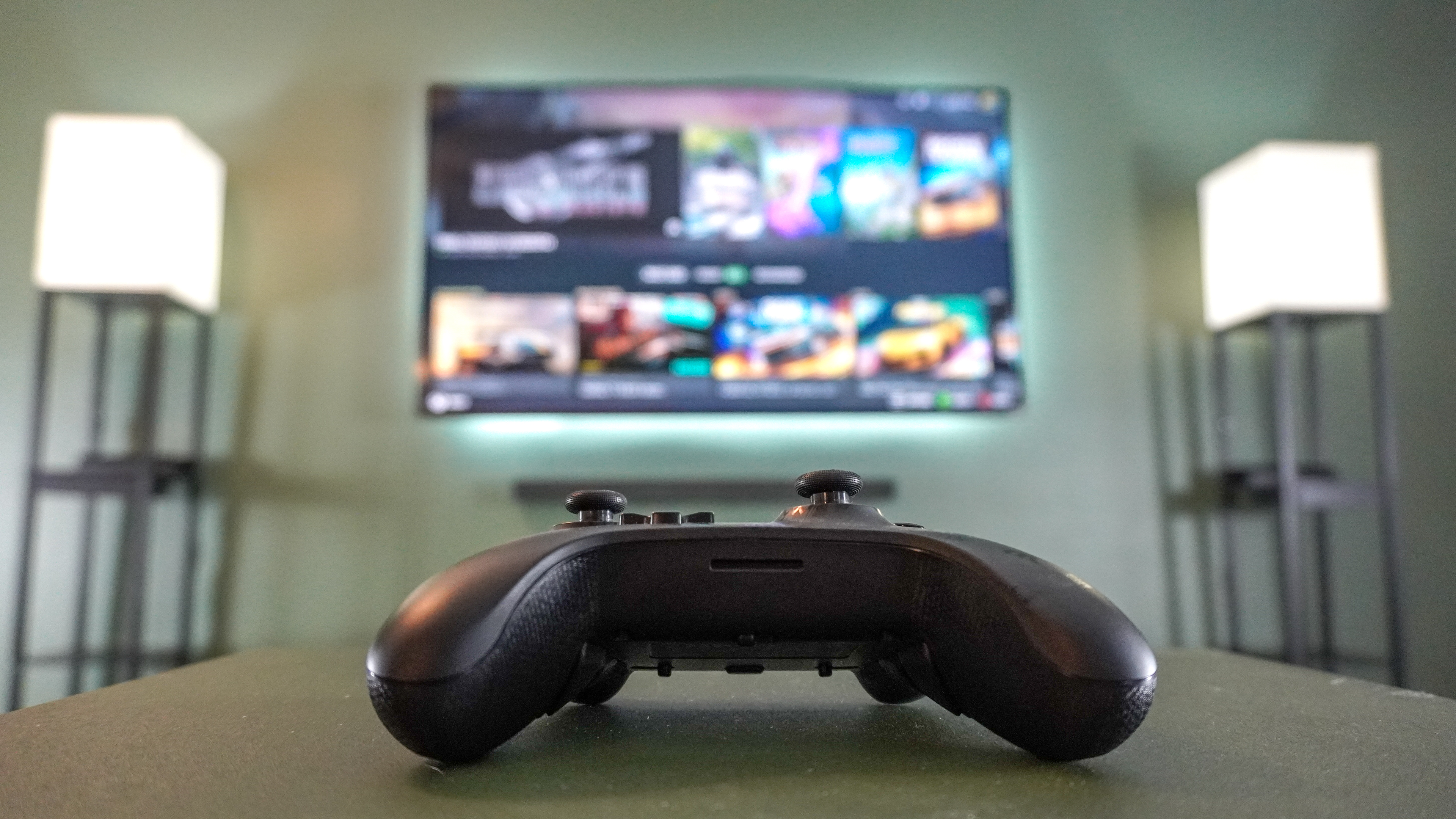 A controller in front of a TV in the living room with Steam Big Picture on screen