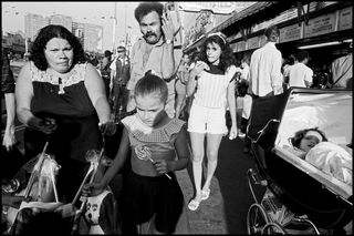 A family walks along the crowded by Bruce Gilden