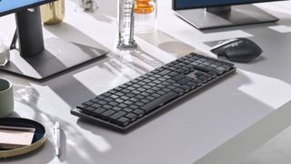 Billede af et Logitech MX Mechanical tastatur og en MX Master 3S-mus på et skrivebord foran en skærm