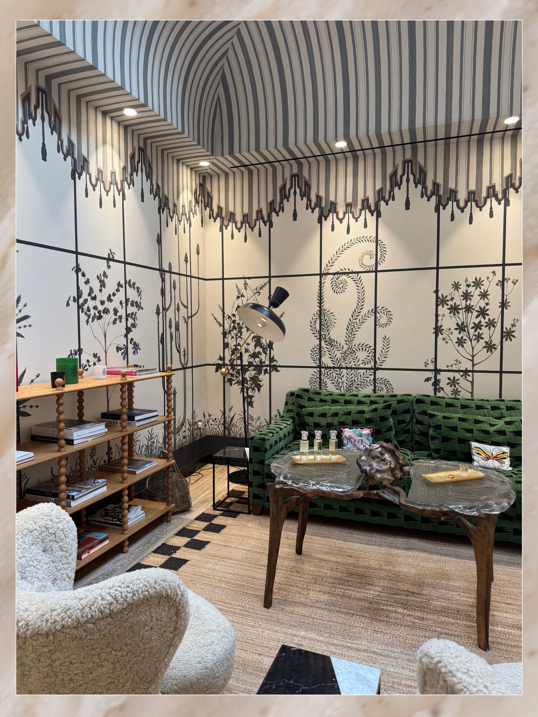 The Maison Sisley interior, with sofas, armchairs and wooden furniture with a floral motif on the wall