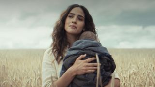 Adria Arjona's Bix holding her baby in the middle of a wheat field