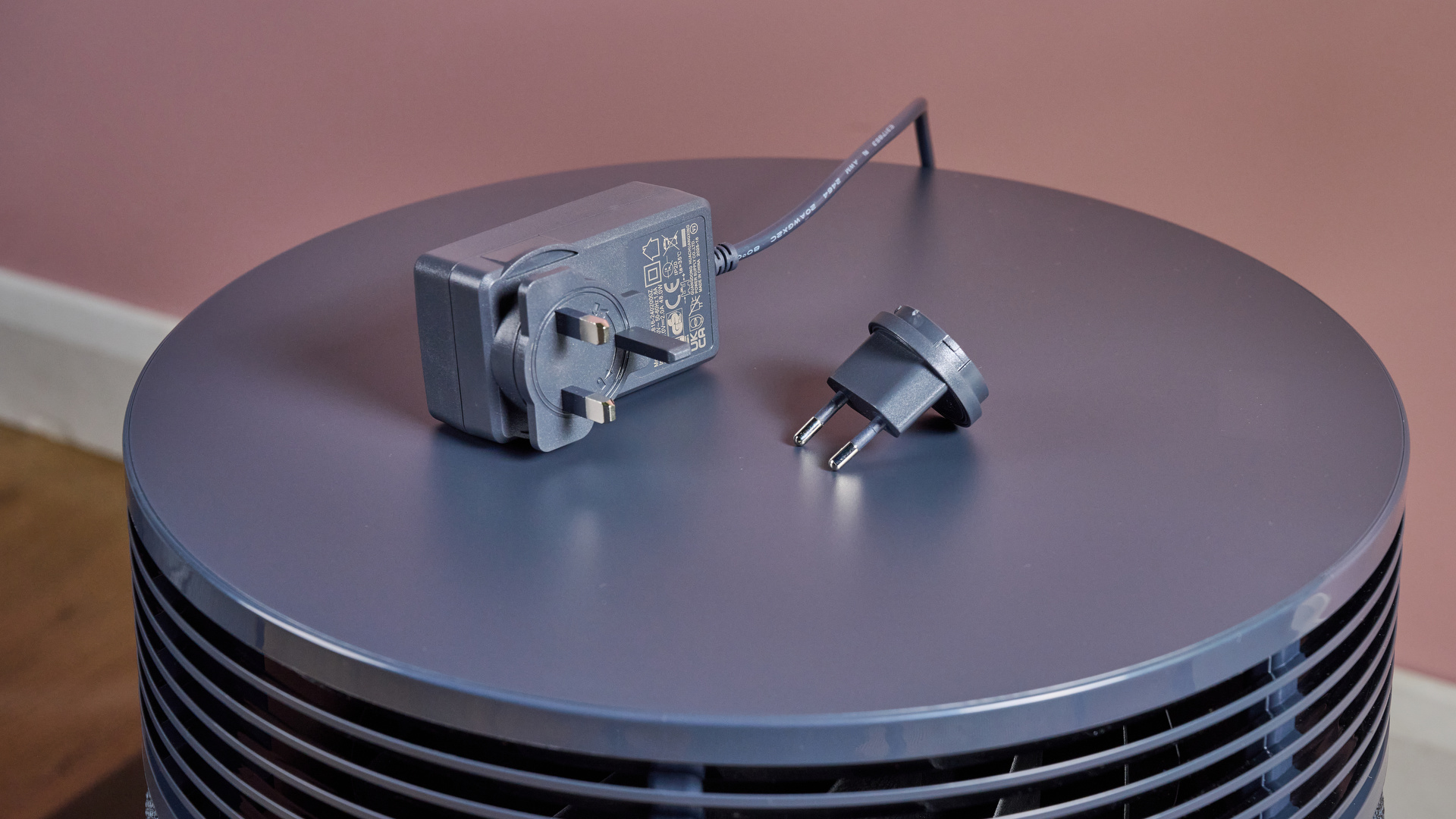 The UK plug is pictured on top of the Blueair Blue Signature air purifier, with the EU plug adapter sitting alongside.