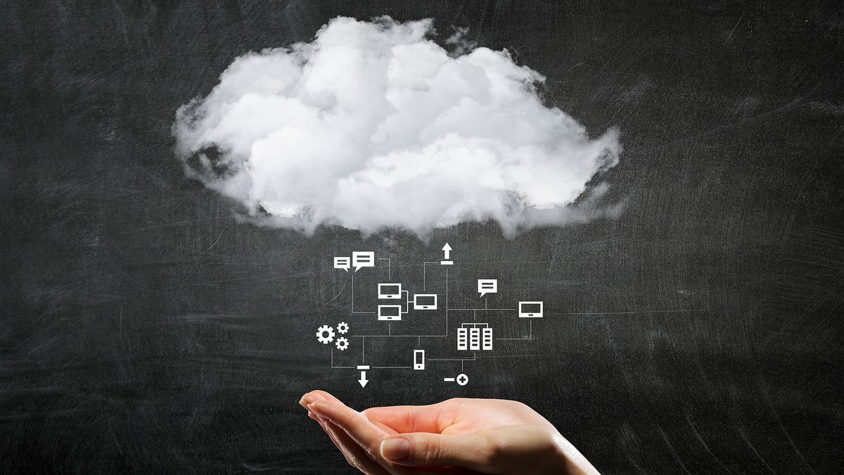 A woman&amp;#039;s hand underneath a small white cloud with icons representing different types of data raining out of it on a black chalkboard background