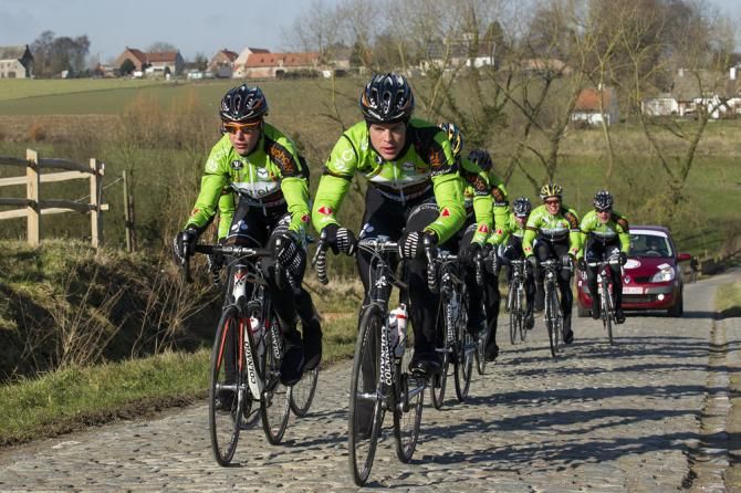 Crelan-Euphony team members pre-ride a cobbled sector of the Omloop Het Nieuwsblad.