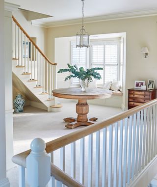 Entryway with two staircases and central pedestal table