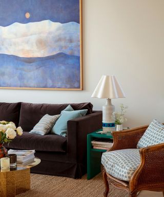 small living room with chocolate brown couch and large blue wall art canvas