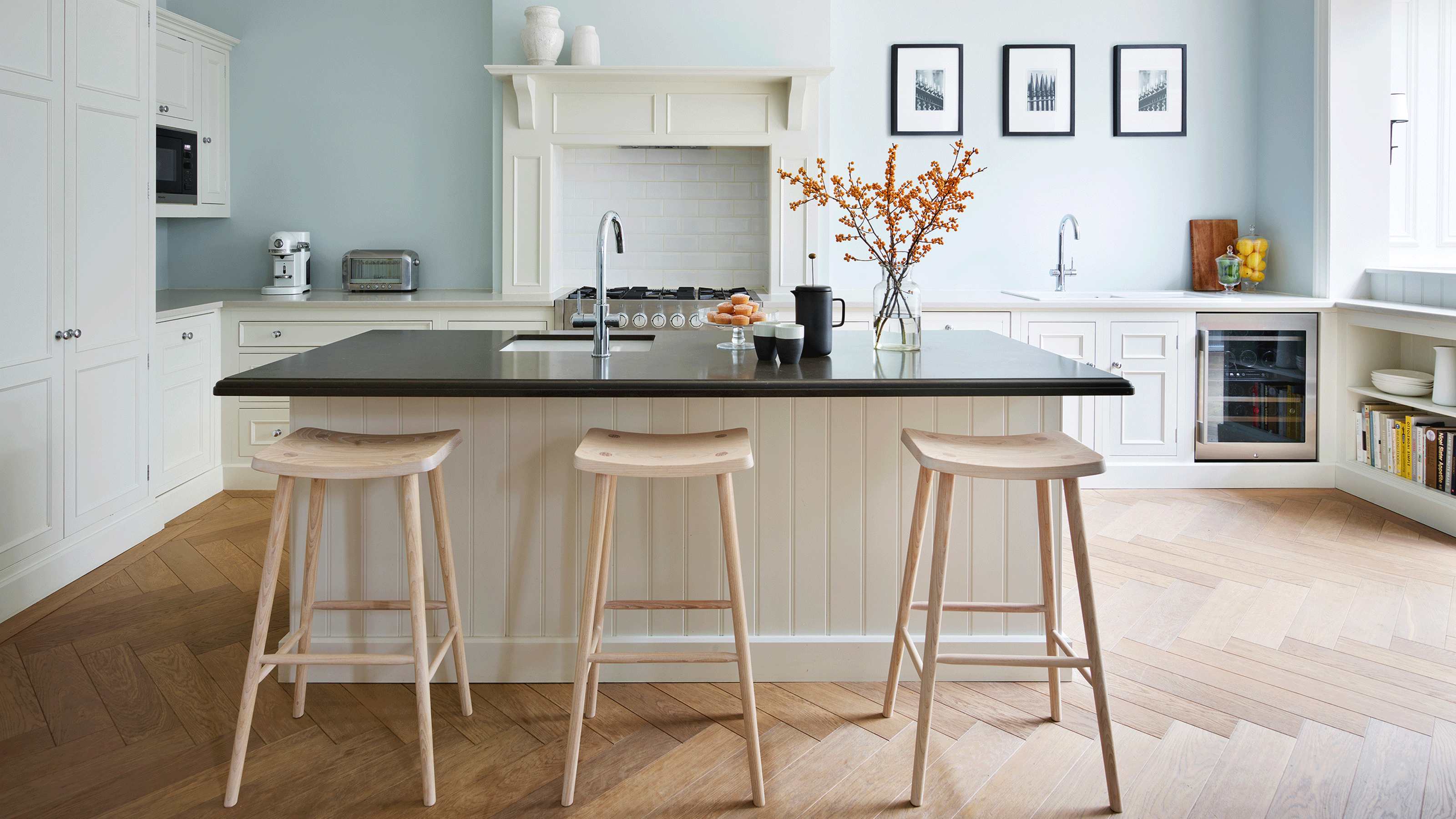 kitchen island with black worktop and wooden stools