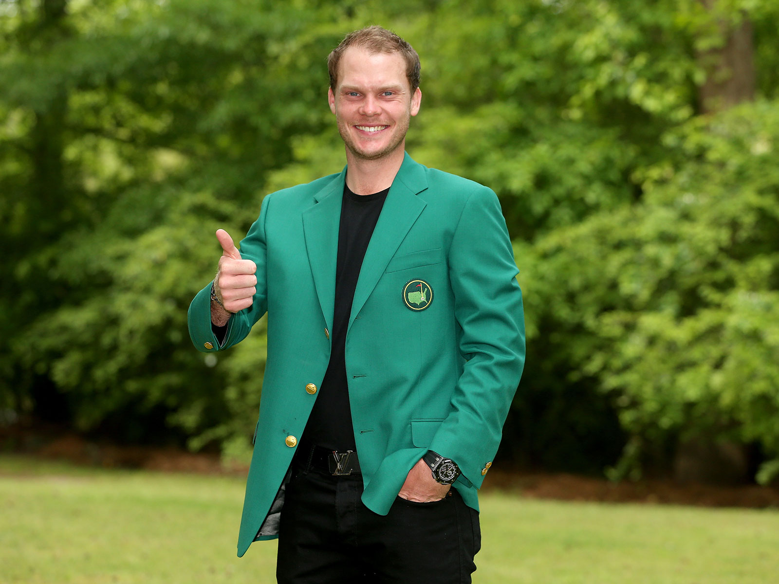 Danny Willett gives a thumbs up while posing in his Green Jacket