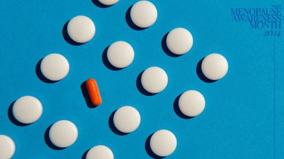 Collection of white pills with orange pill in the middle to represent contraception in perimenopause