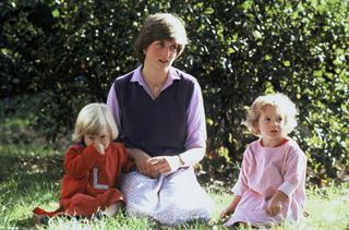 Princess Diana and children sitting in the grass