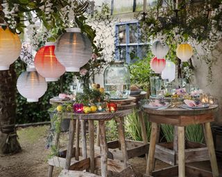Colorful paper lanterns arranged in a party style covered patio with high wooden tables