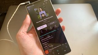 Sony XPeria 1 V streaming Tidal 360 Reality content, held in a hand on gray background