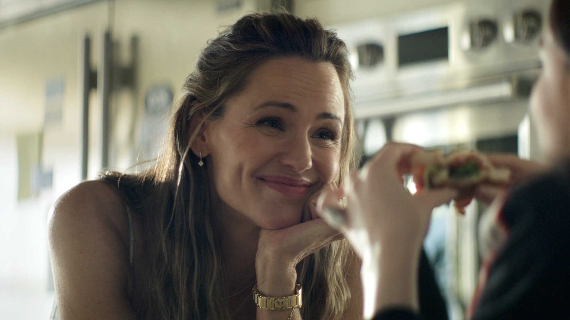 Hollis smiling watching her daughter eat a sandwich in The Five-Star Weekend.