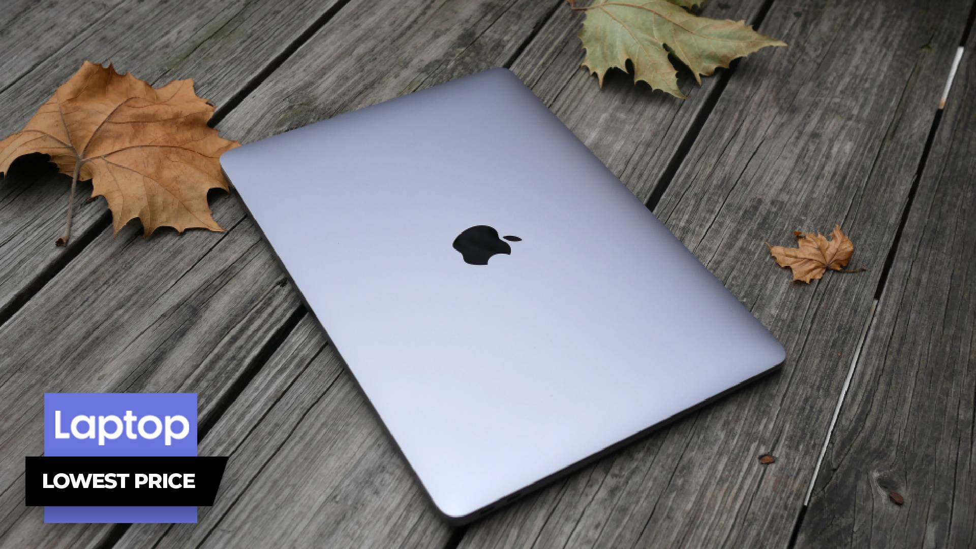 MacBook Air M1 closed on a deck with fallen leaves around it - Laptop Mag lowest price banner in corner