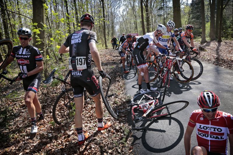 Michael Reihs surveys the crash site while holding a broken front wheel in his hand