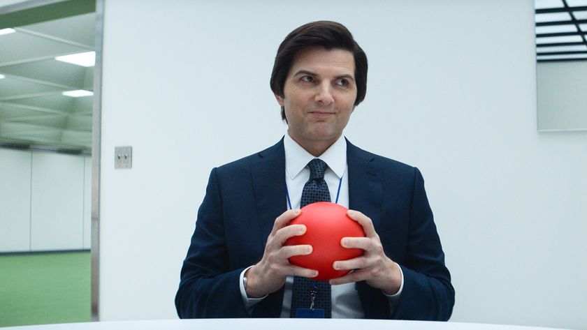 Mark S holding a red ball while smiling and sitting down in Severance season 2