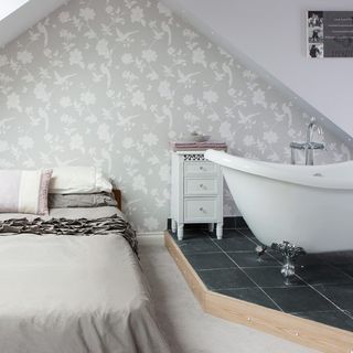 en suite bedroom with printed walls and white bathtub