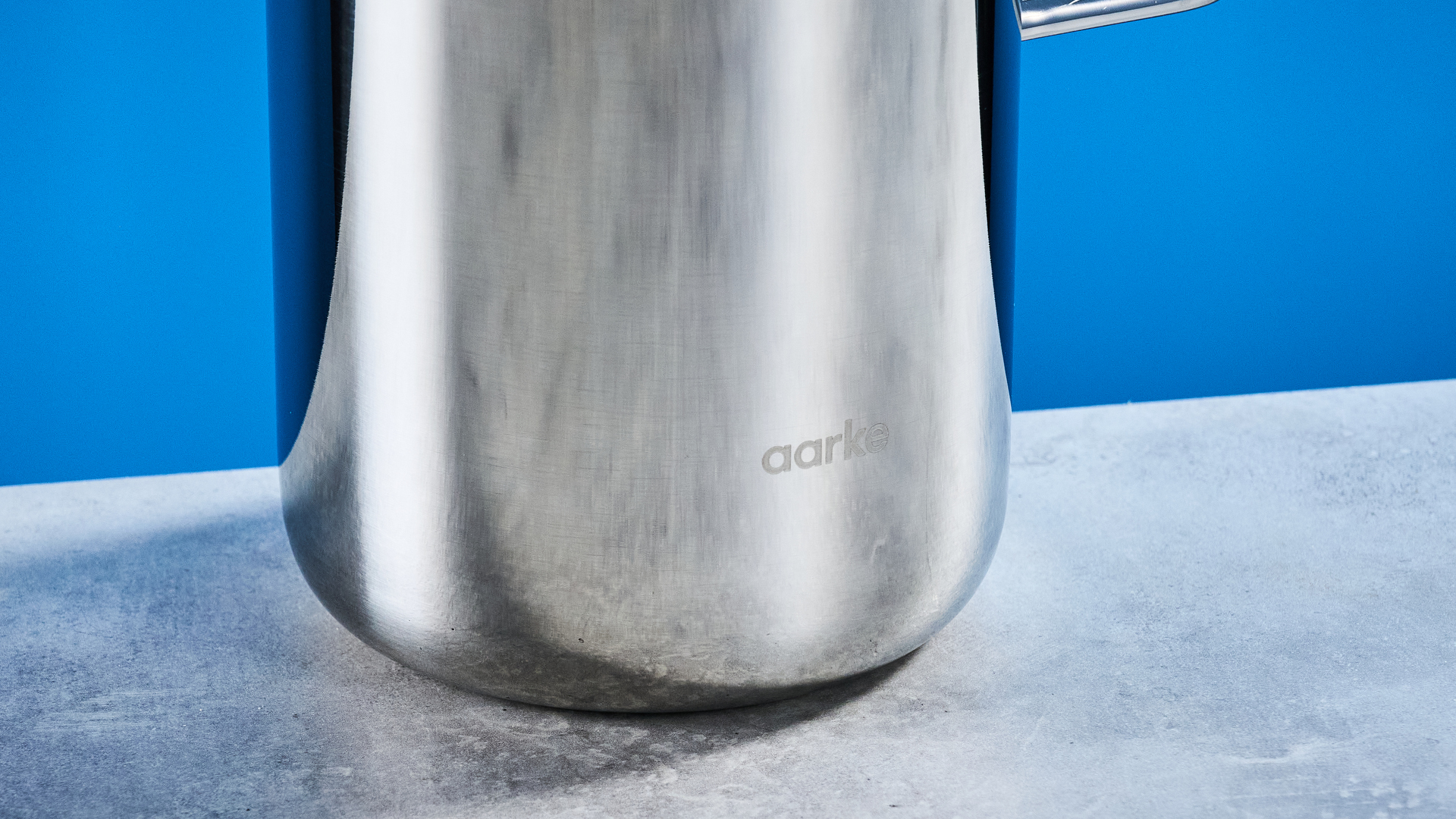 the aarke french press in silver showing the french press filter system, lid, spout, and inside photographed against the blue tom's guide background