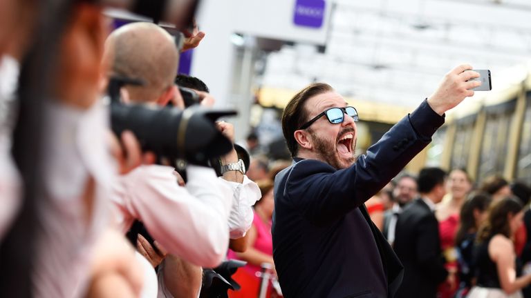 Ricky Gervais taking a selfie on the red carpet.