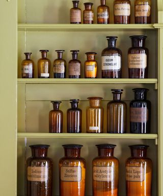 Green bathroom cabinet with brown glass medicine bottles