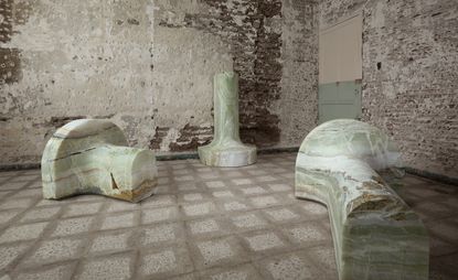 Marble igloo statues in a room by Ana Mendieta