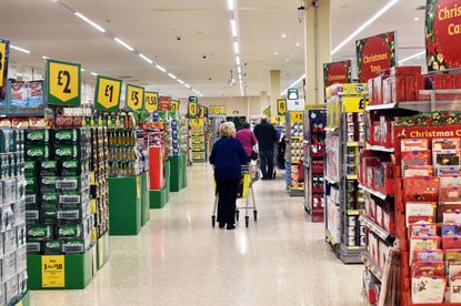 When is the best time to do Christmas food shopping? Large Aisle of a supermarket at Christmas with special offers on the end aisles.
