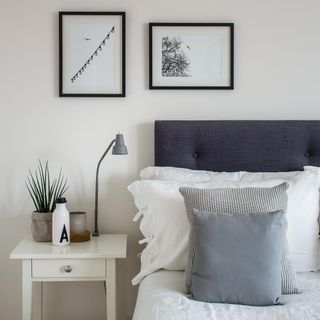 bedroom with white wall and lamp on bedside table