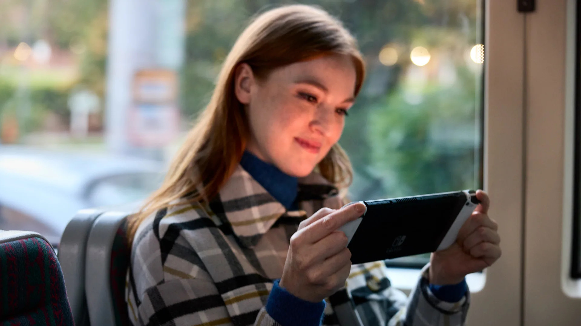 Woman playing Nintendo's new Switch OLED console