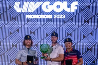 Kalle Samooja of Finland (centre) lifts the trophy while Kieran Vincent of Zimbabwe (left) and Jinichiro Kozuma of Japan (right) celebrate gaining LIV Golf membership for season 2024 at the LIV Golf Promotions at Abu Dhabi Golf Club on December 10, 2023 in Abu Dhabi, United Arab Emirates.