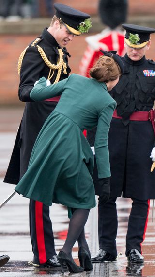 Prince William supports Kate Middleton as her heel is stuck in a drain grate at Mons Barracks in 2013