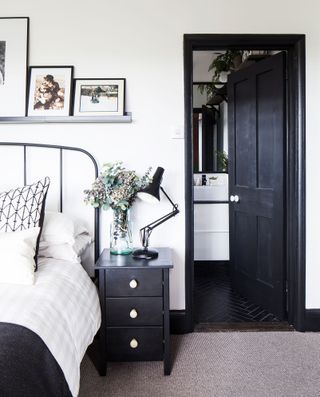 A monochrome bedroom with white walls and black woodwork