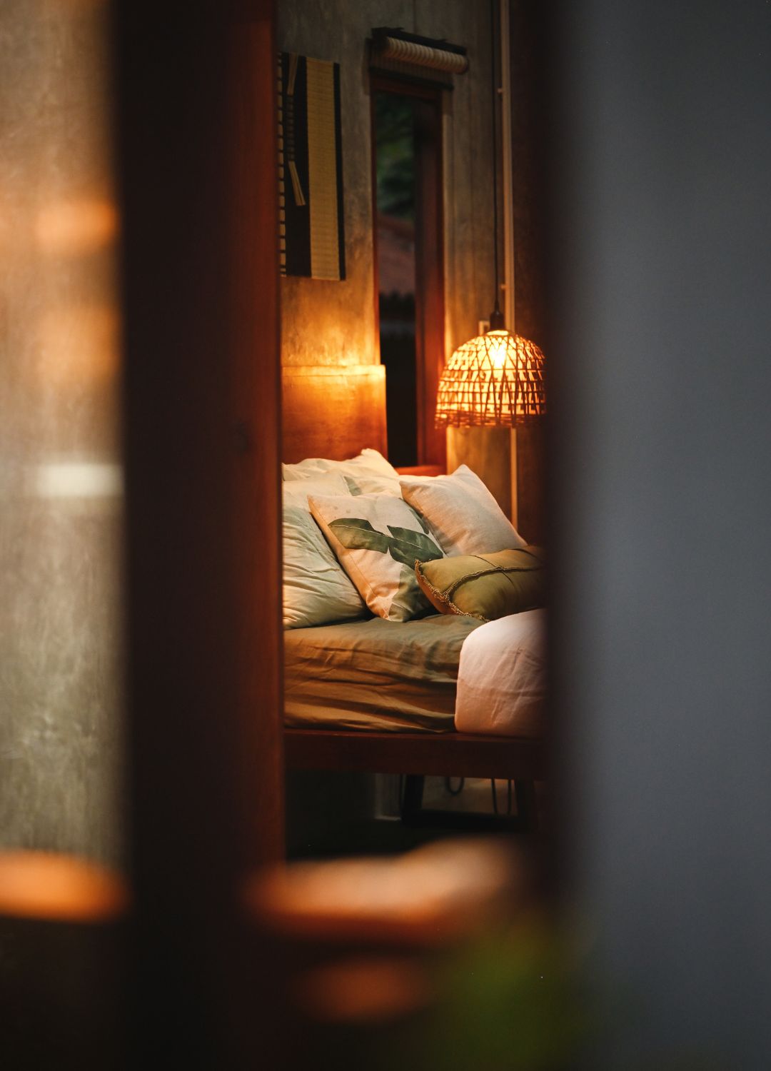 picture of a cosy bedroom with warm rattan lamp on