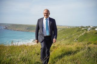Liberal Democrats leader Ed Davey walking on a clifftop by the seaside