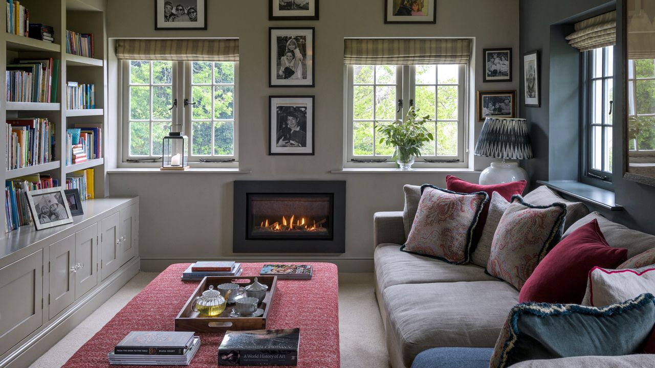 A living room with a built-in library and an electric fireplace