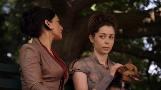 Cristin Milioti sitting next to Kalinda while petting a dog that is sitting in her lap.