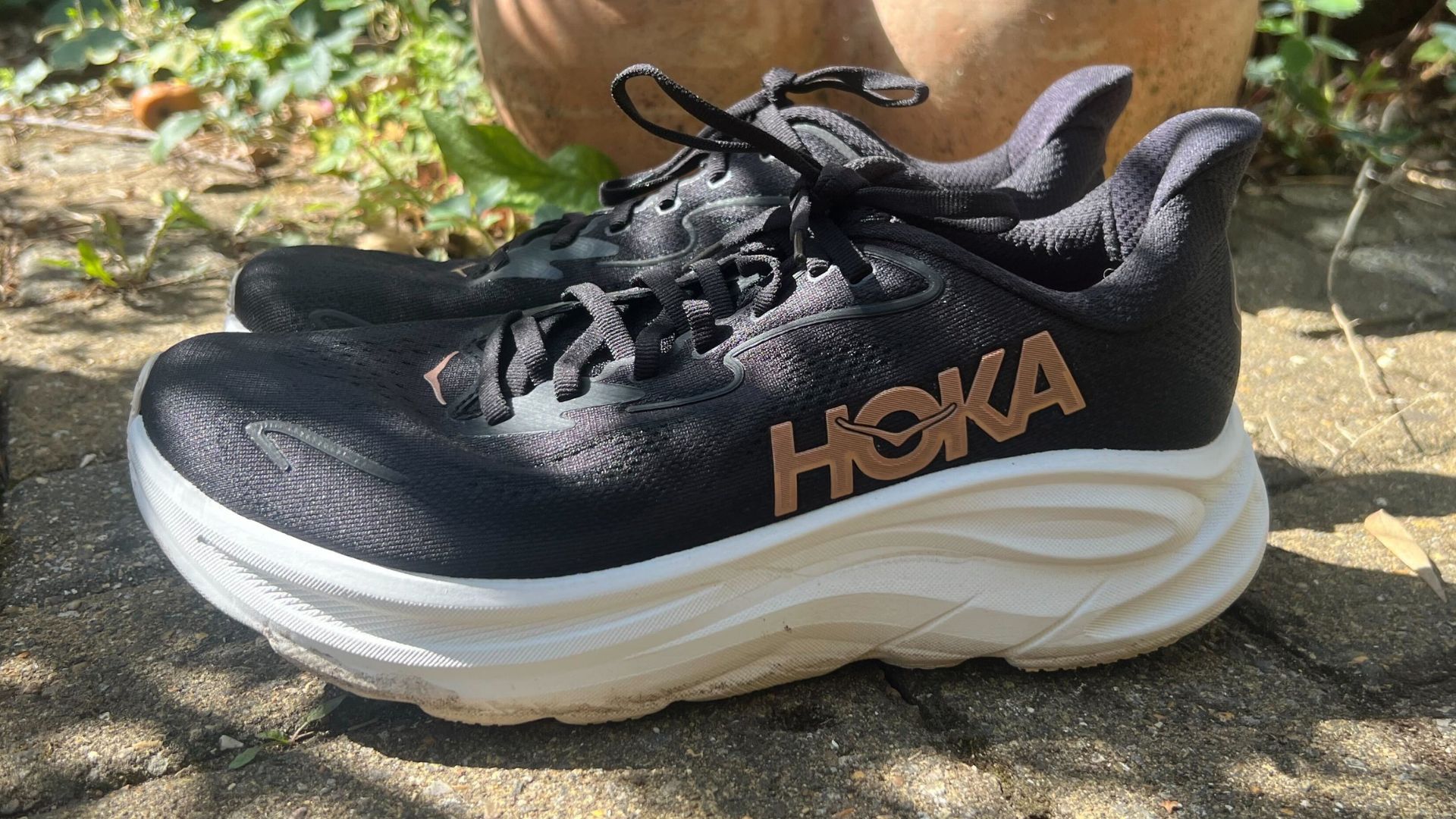 Grace Walsh's Hoka Clifton 10 running shoes sitting on pavement