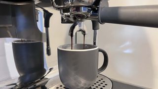Espresso machine pouring espresso shot into cup