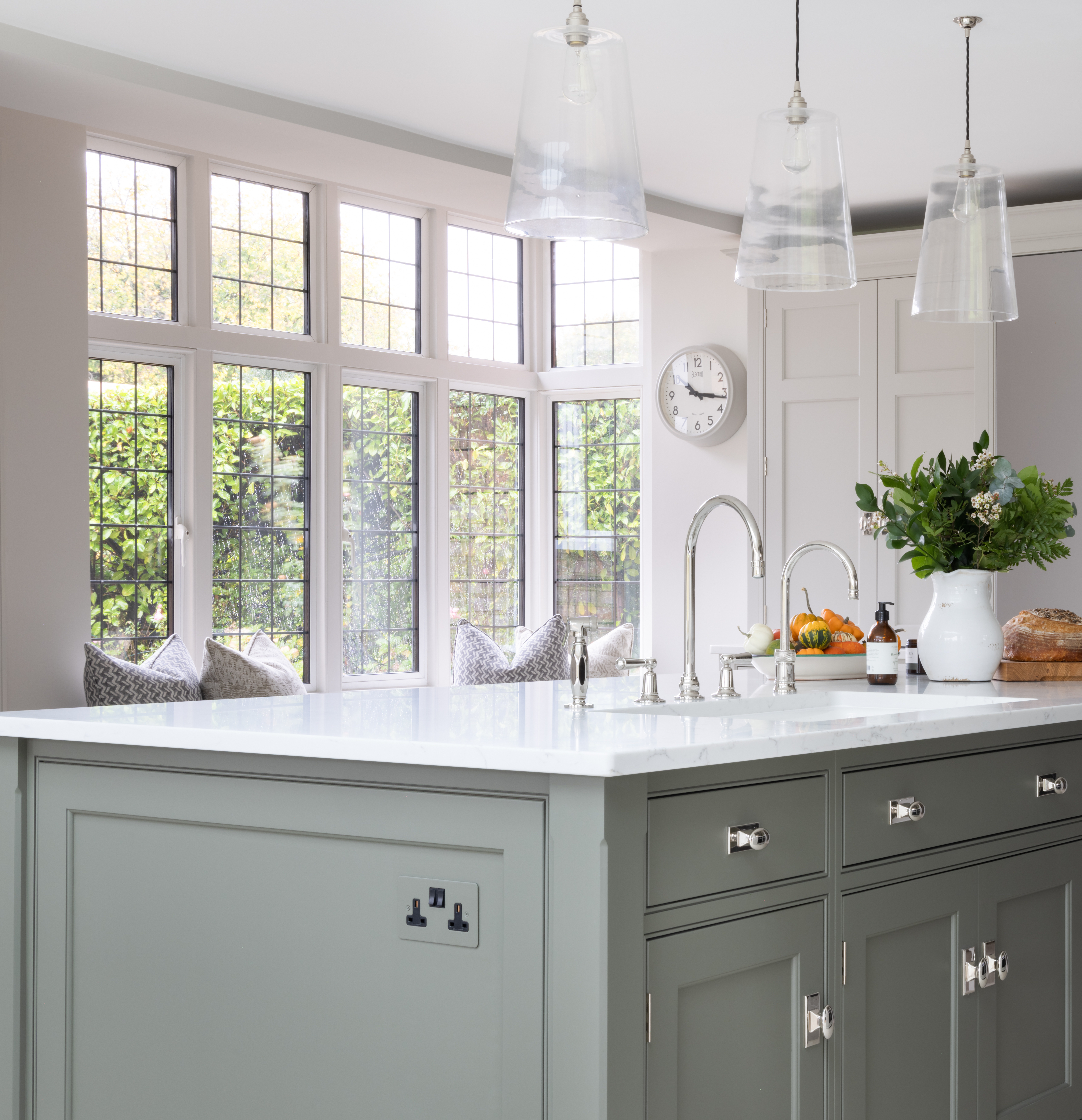 A kitchen island in green with the socket painted the same color as the island