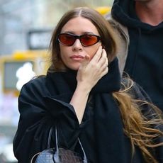 Ashley Olsen, in an all-black outfit and The Row Lady Bag, and Nicolas Turko walking in New York City