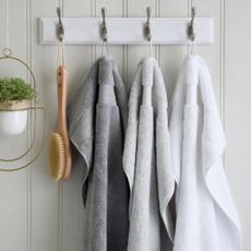 Scooms Egyptian Cotton Bath Sheets in three colours hanging on hook in bathroom
