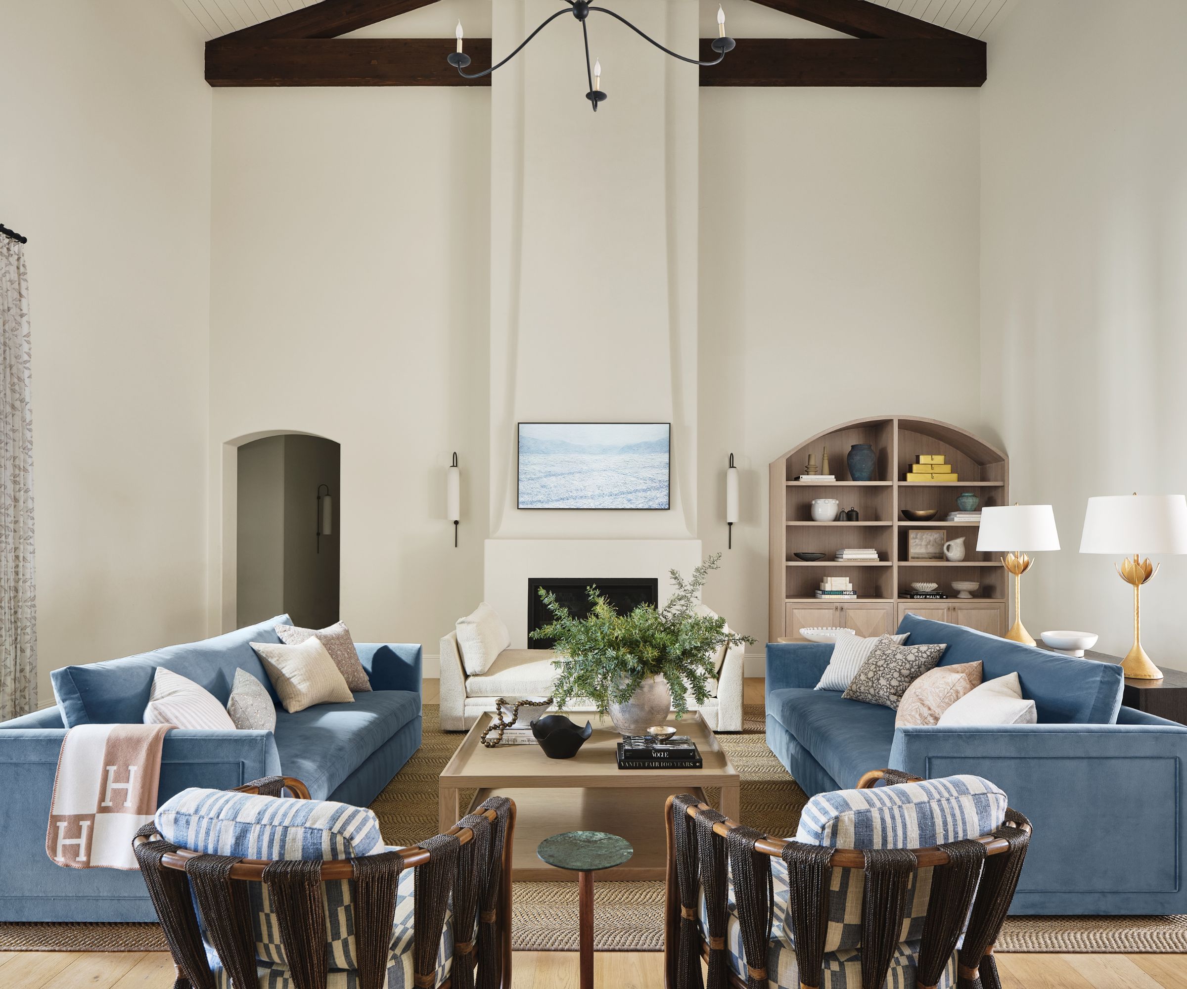 living room blue sofas with white walls high ceilings and beams