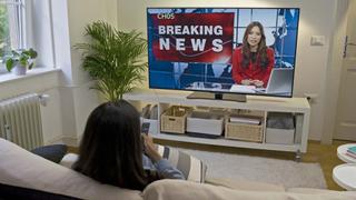 Woman watching TV news