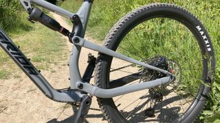 Close up of rear wheel on mountain bike with path and grass behind