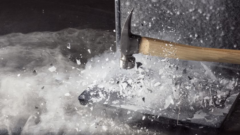 A hammer smashing a laptop computer.