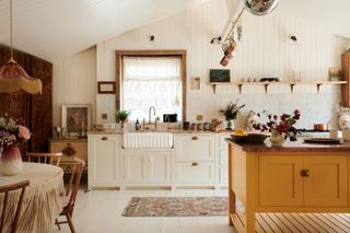 white deVOL kitchen with orange island in Pearl Lowe's boho beach house