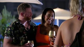 Stephen Richardson and Monica Roberts, holding golden goblets while speaking with Hannah Jiles at an outdoor restaurant, on 'Love is Blind' season 7.