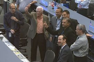 Apollo 17 moonwalker Gene Cernan (left) gives a thumbs up to the astronauts on the International Space Station from Mission Control in Houston on Tuesday, Feb. 5, 2013.