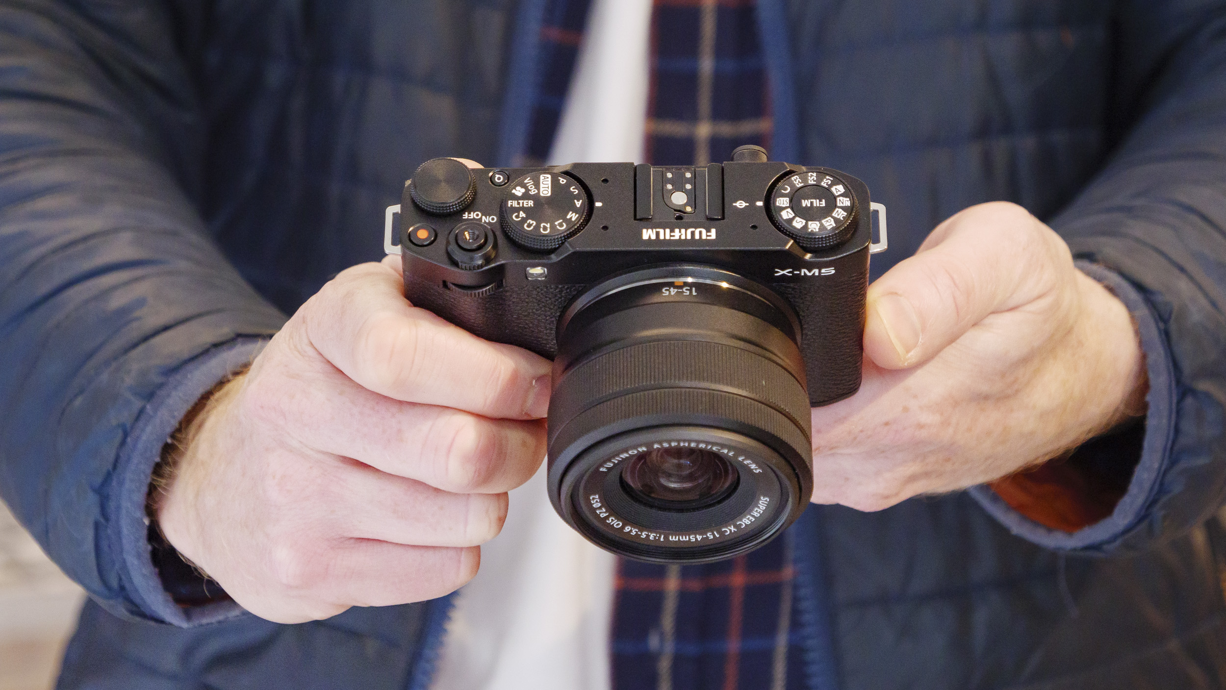 Fujifilm X-M5 camera with 15-45mm lens, in the hand