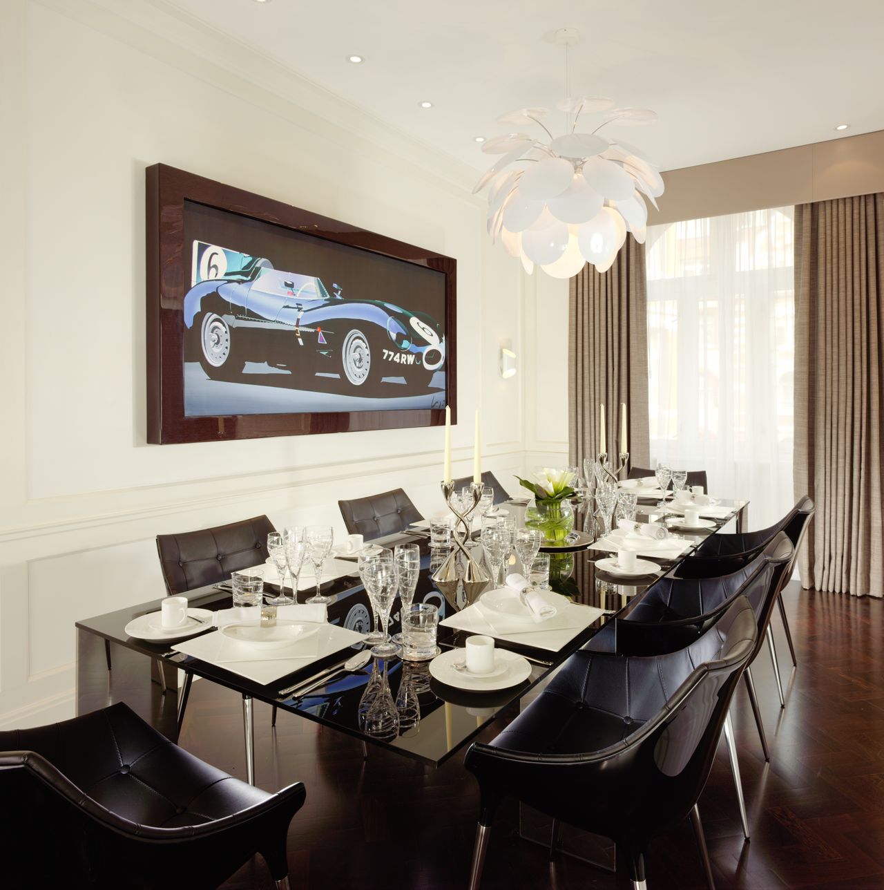 The dining room at the Callum Suite, with black furniture and a nice painting of a jaguar e-type