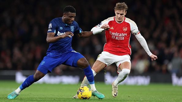 Mohammed Kudus of West Ham United controls the ball whilst under pressure from Martin Odegaard of Arsenal during the Premier League match between Arsenal FC and West Ham United at Emirates Stadium on December 28, 2023 in London, England.